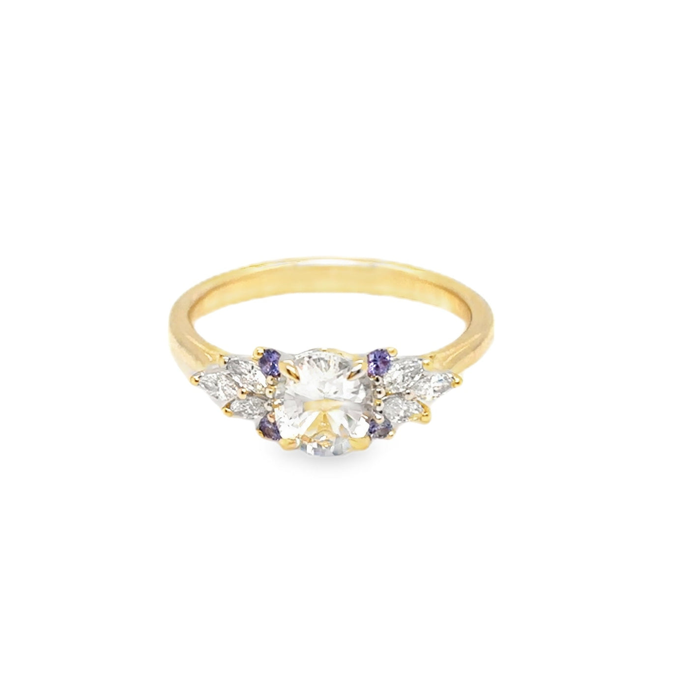 Gold ring with clear and purple gemstones on a white background